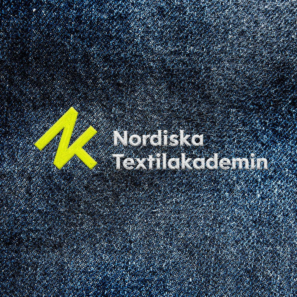 Nordiska Textilakademin logotyp broderad på tyg